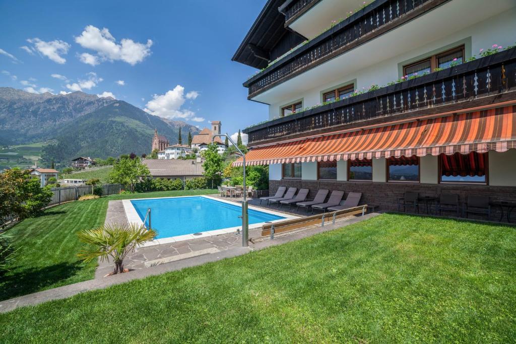 a swimming pool in the backyard of a building at Gartenheim App Elisabeth in Schenna