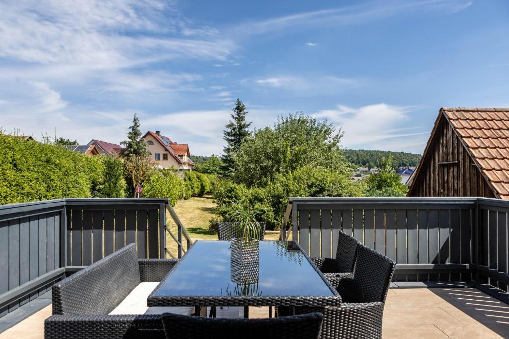 a patio with a table and chairs on a deck at Ferienhaus Barockhaus Fulda in Petersberg