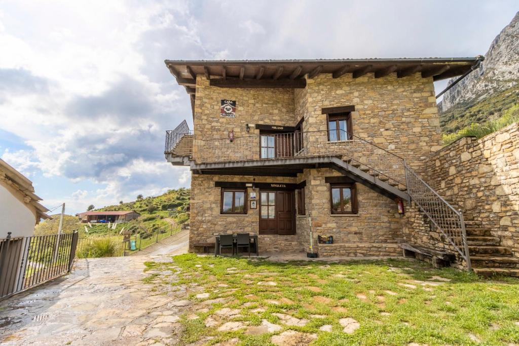 a stone house with a staircase in front of a building at Xisqueta in Campo