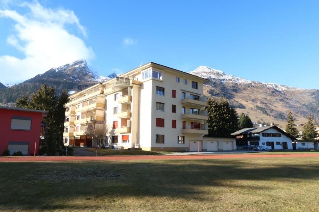 a large building with mountains in the background at Apartment Bünda in Davos