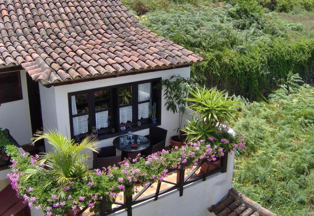 a house with a balcony with flowers on it at Aptos Monasterio de San Antonio 4 in Icod de los Vinos