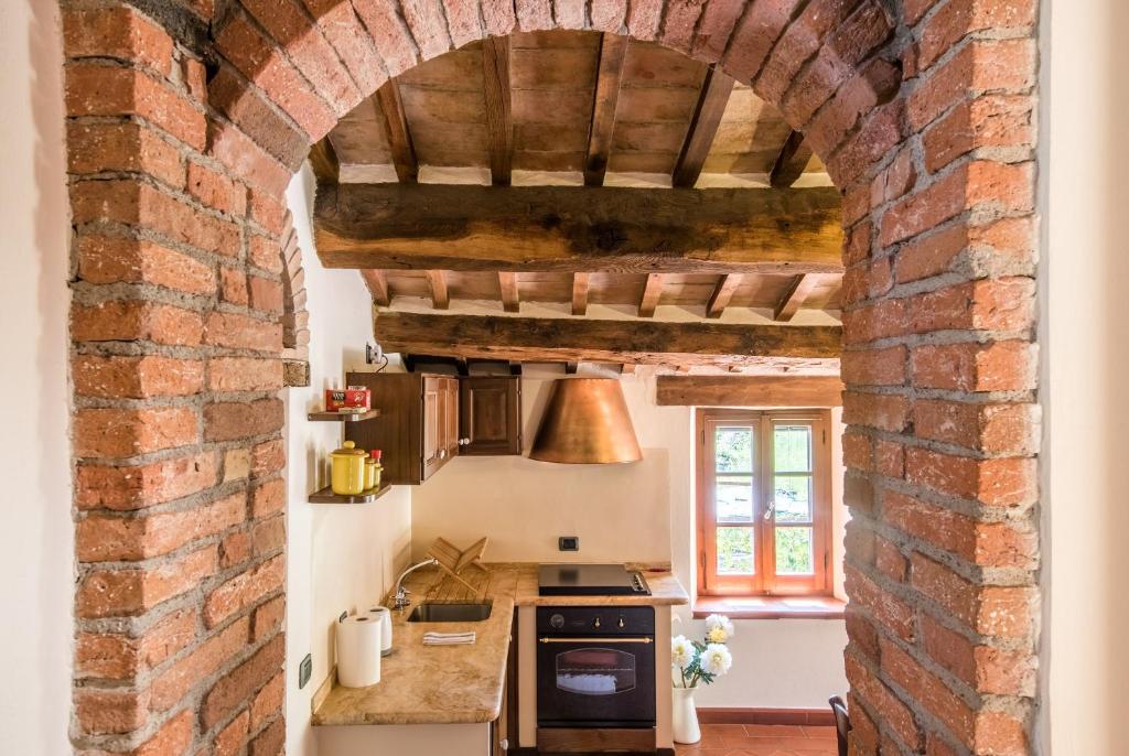 an archway in a kitchen with a brick wall at Appartamento Gemma Bianca-tavoleto in Castiglione dʼOrcia