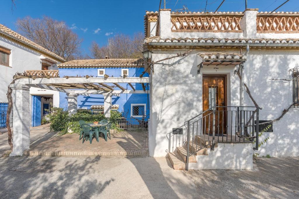 a white building with a balcony and a table at Apartamento El Tinao in La Zubia