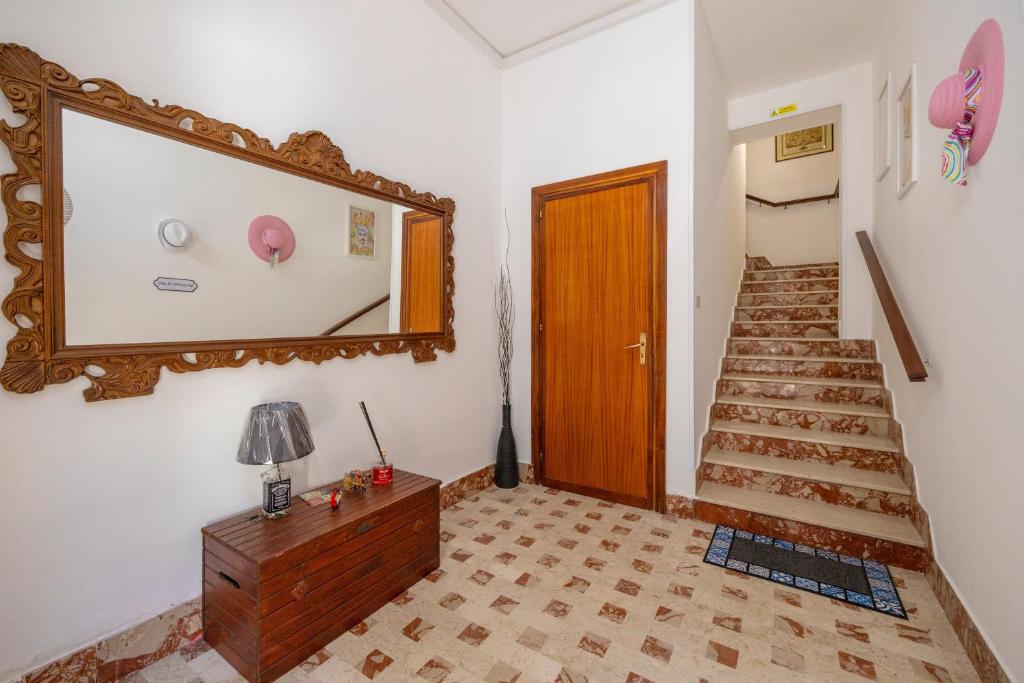 a room with a mirror and a staircase with a table at Sole e Amore in Casteldaccia