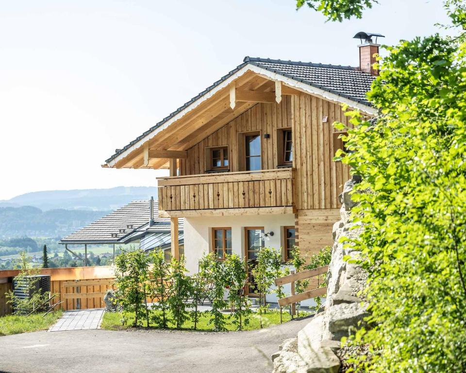 a wooden house with a bench in front of it at Waldchalets & Ferienwohnungen Allgäu in Burgberg