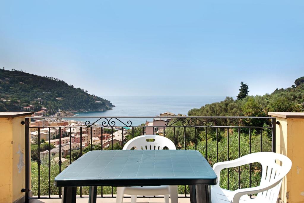a table and chairs on a balcony with a view of the ocean at Villa Ciò in Bonassola