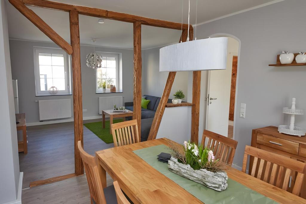 a dining room and living room with a wooden table at Ferienhaus Eifelträume, Birresborn in Birresborn