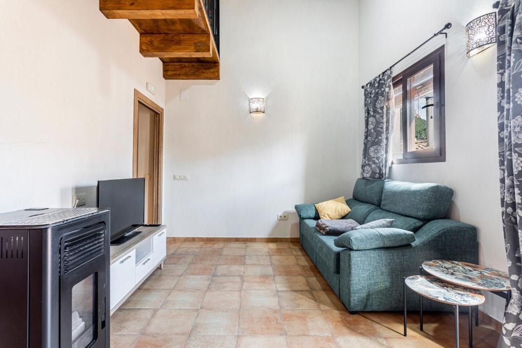 a living room with a couch and a tv at Entre Eras Apto Rural Los Vencejos in Ademuz