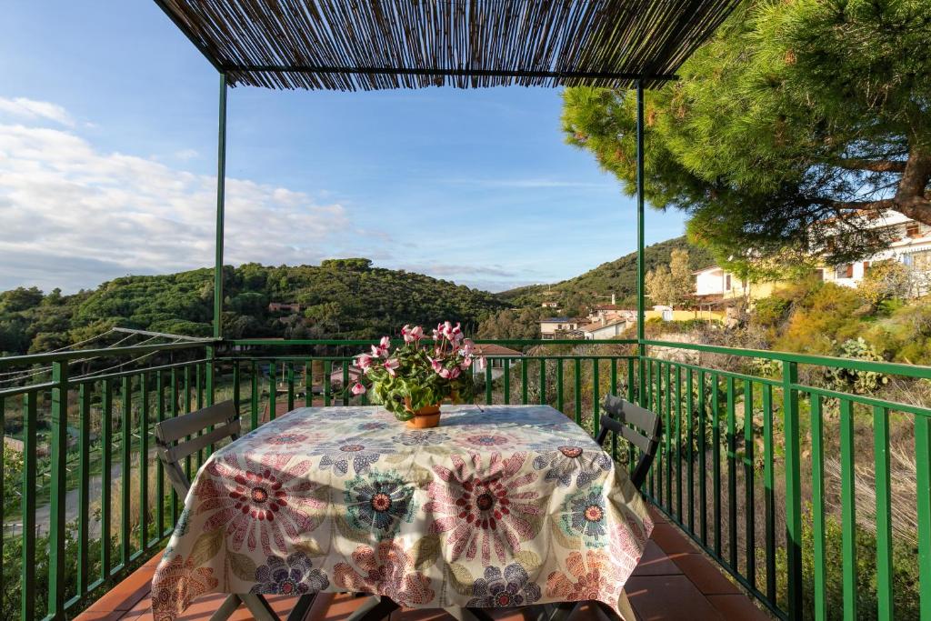 a table with a vase of flowers on a balcony at Simona in Fetovaia