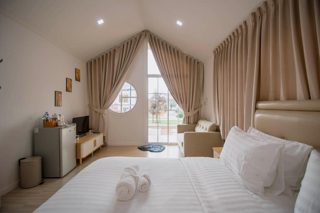 a bedroom with a bed with two slippers on it at Terra Sky Home in Pak Chong