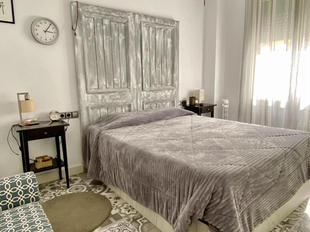 a bedroom with a large bed and a clock on the wall at Reconnectar Malgrat de Mar Emili in Malgrat de Mar