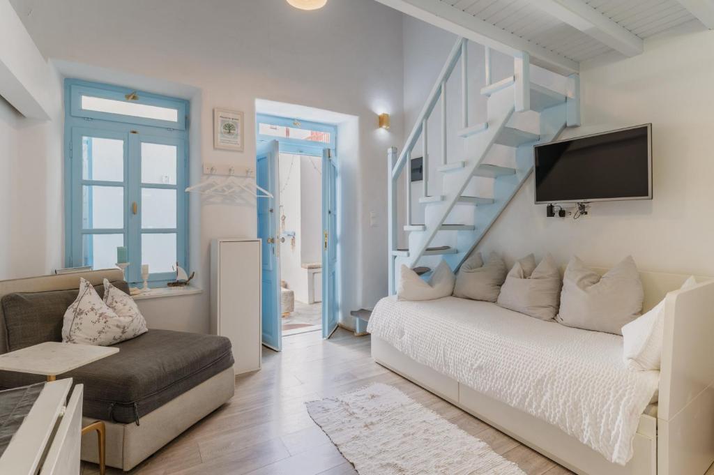 a living room with a bed and a staircase at 5-Bed Stylish Maisonette in Mikonos