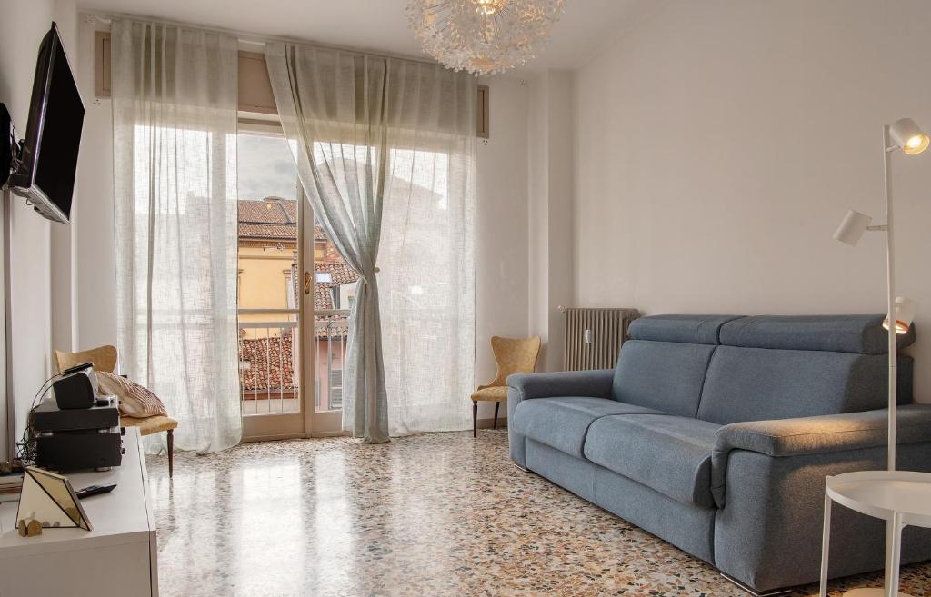 a living room with a blue couch and a window at De Rolandis in Asti