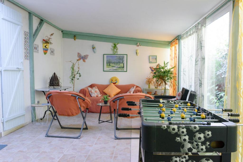 a living room with a foosball table and chairs at Chambres D'hôtes in Saint-Cyprien