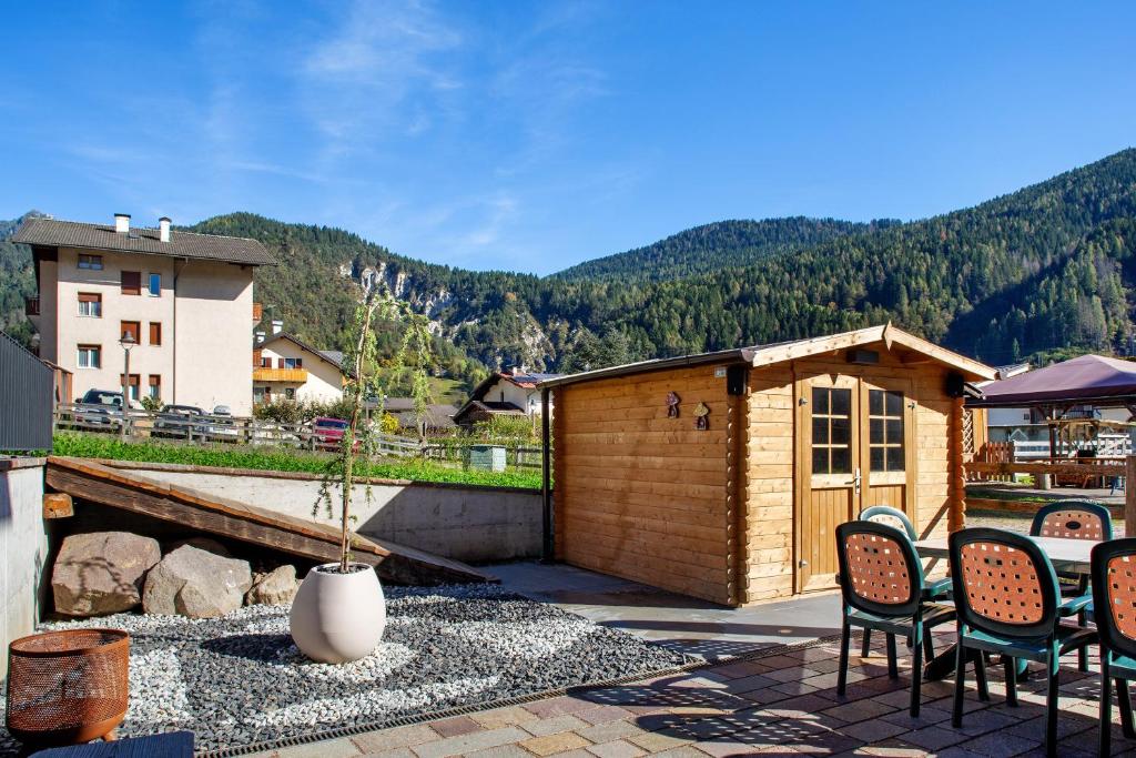 a patio with chairs and a building with mountains in the background at Dimora Vacanze in Mezzano