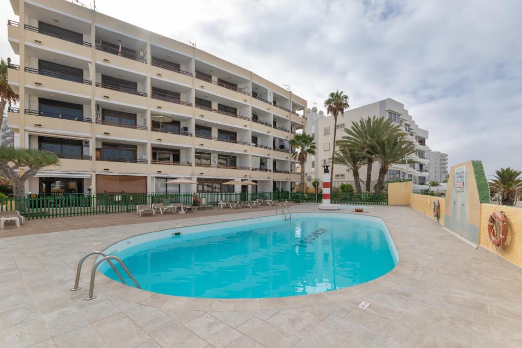 a swimming pool in front of a building at Lirio Blanco de las Dunas Canarias in Playa del Ingles
