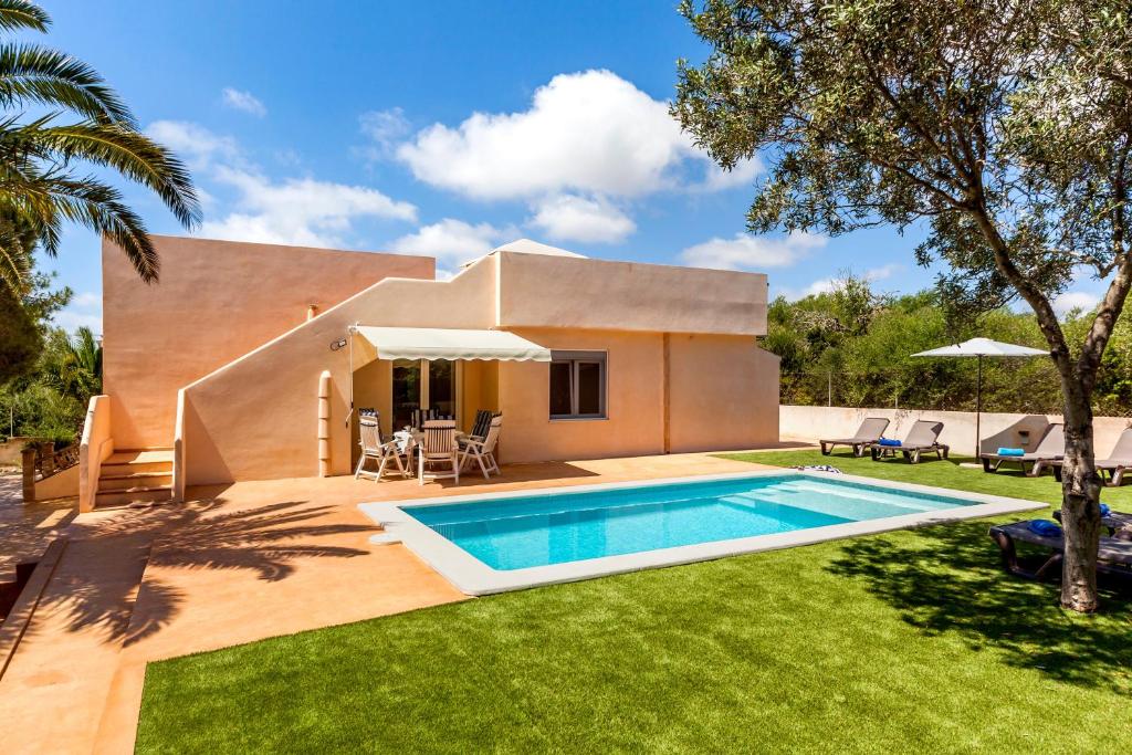 a villa with a swimming pool in front of a house at Casa Antonio Invierno in Cala Llombards