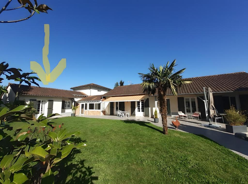 a house with a palm tree in the yard at Chambre D'hôtes Agapanthe in Feytiat