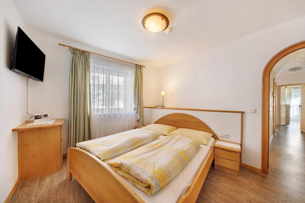 a bedroom with a bed and a television in it at Ferienwohnung Innerwalten 200 in San Leonardo in Passiria