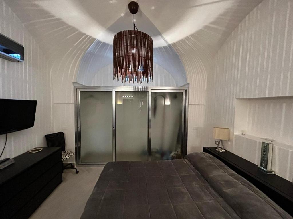 a room with a large bed and a chandelier at Dammuso Cristoforo Colombo in Pantelleria