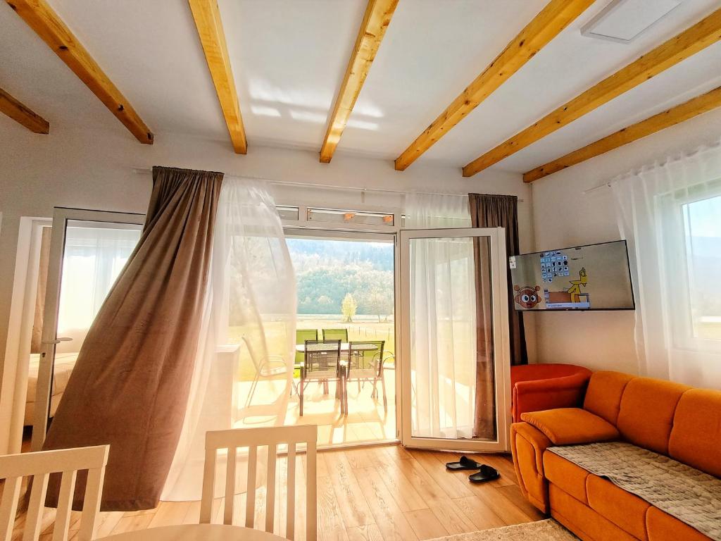 a living room with an orange couch and a balcony at Kucica na Drini MINJA in Višegrad