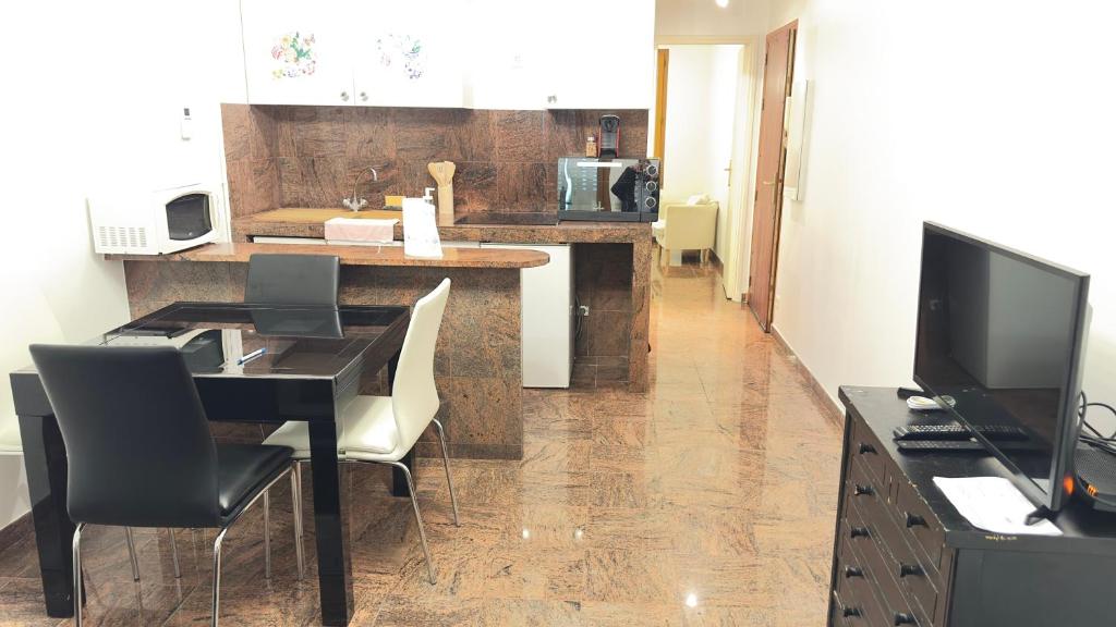 a living room with a dining table and a television at Le Magnifique 3 personnes Drancy in Drancy