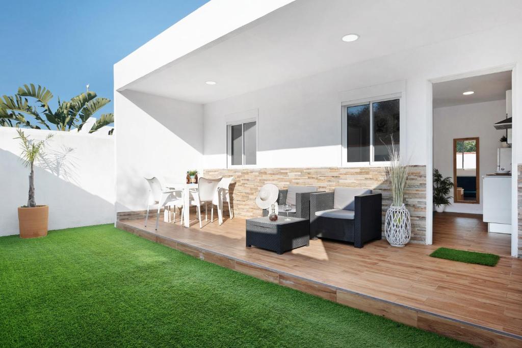 a living room with a table and chairs and grass at Zahora Qg in Barbate