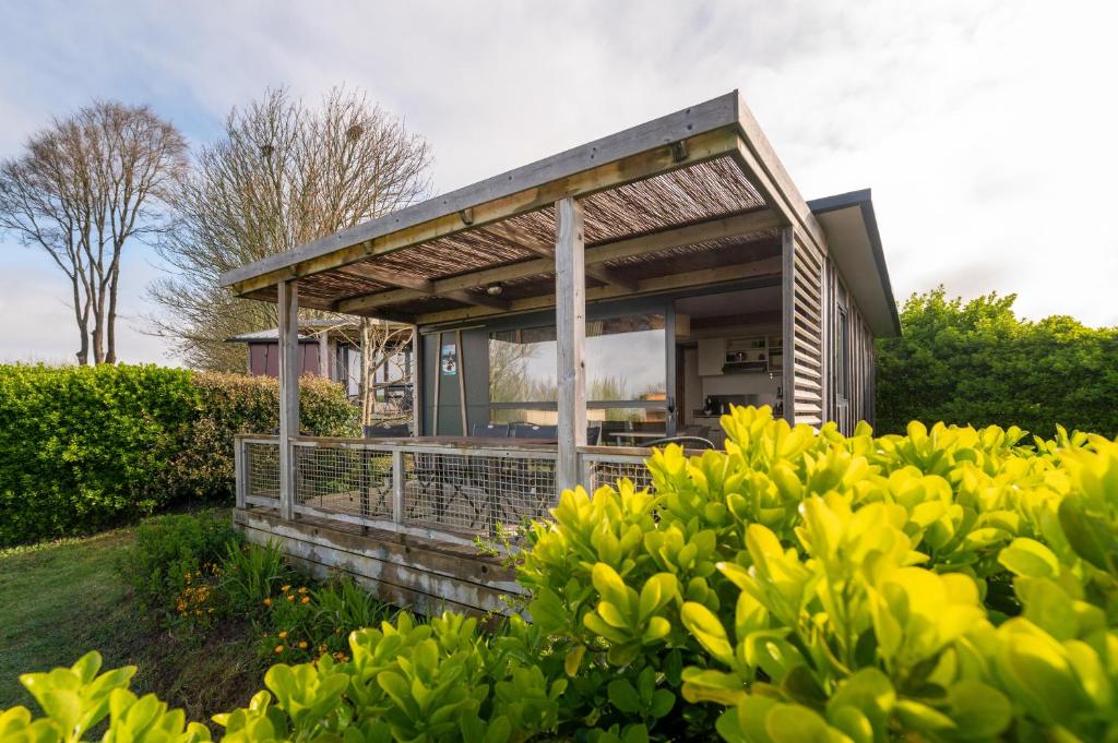 a house with a large window in a garden at Chalet 25m2 - Pierres Noires in Plouhinec