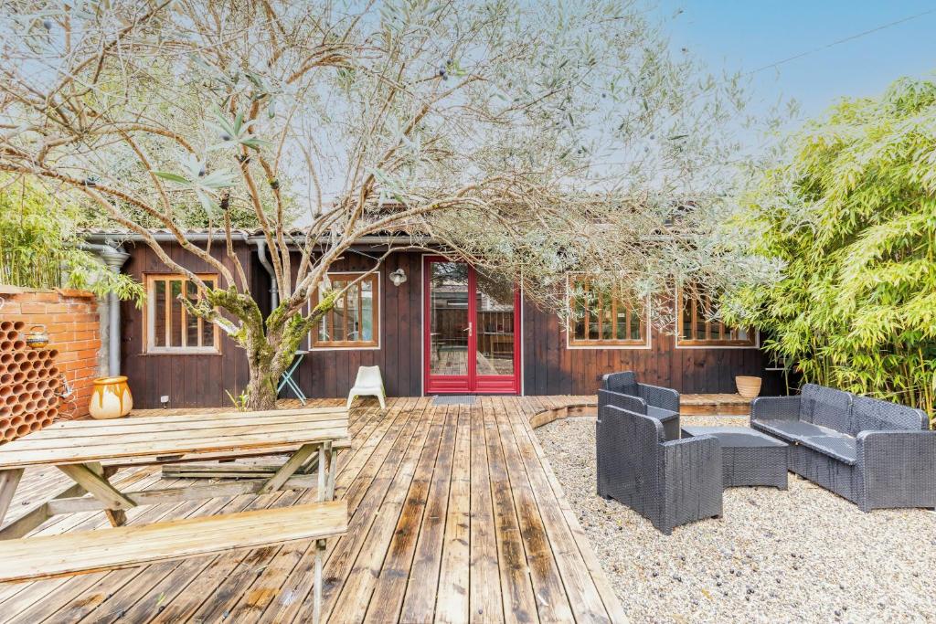 a house with a red door and a wooden deck at La Cabane d'Ana in Bordeaux