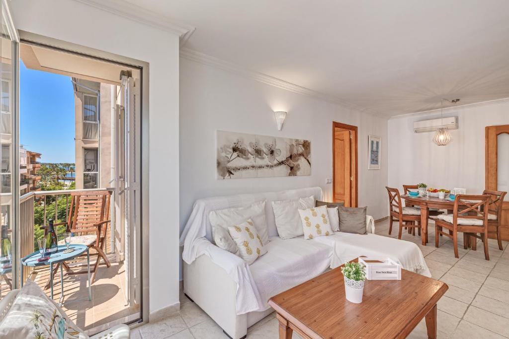 a living room with a white couch and a table at Mariners in Alcudia