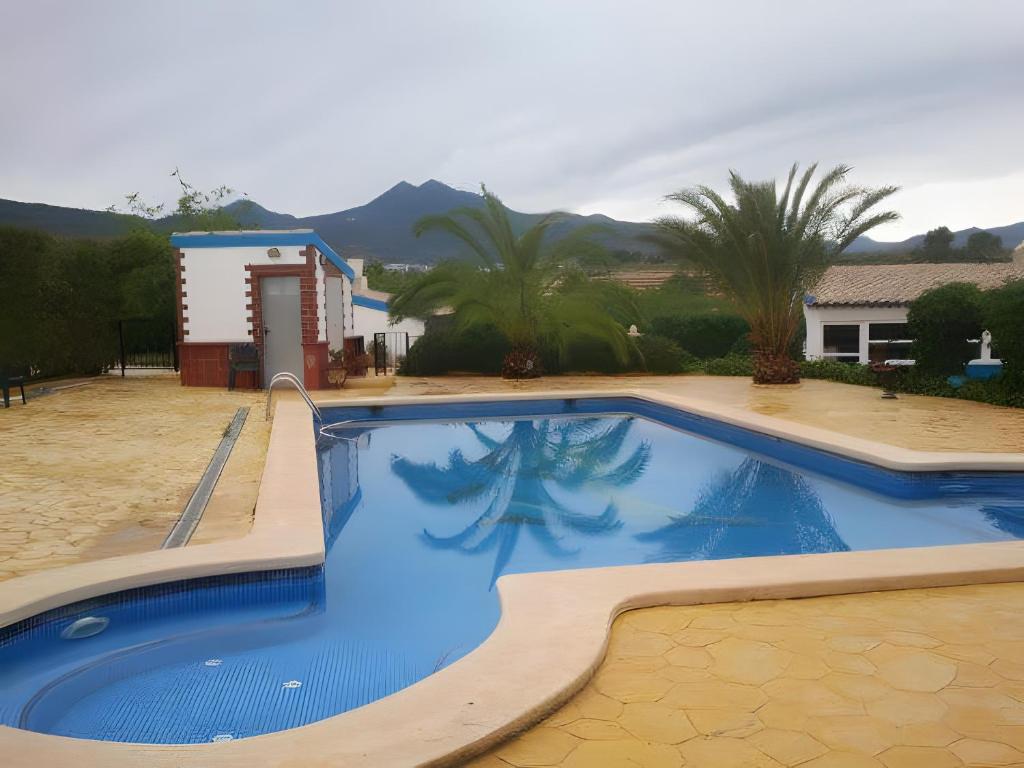 a large blue swimming pool in a yard at Agroturismo El Serrano in Moratalla