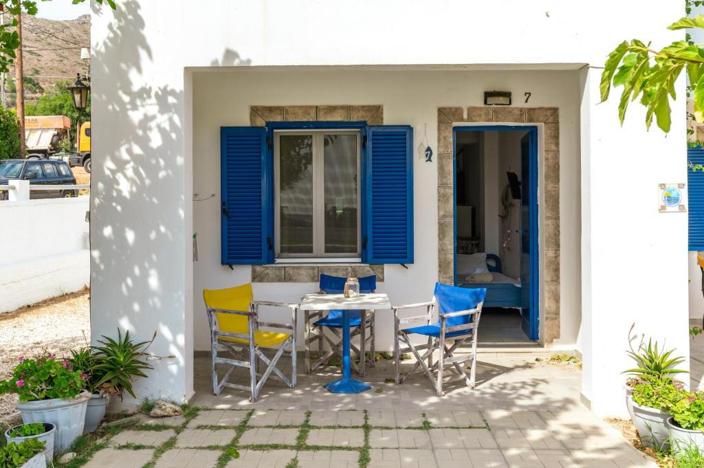 a table and chairs in front of a house with blue shutters at Perasma Studios 7 in Kipri