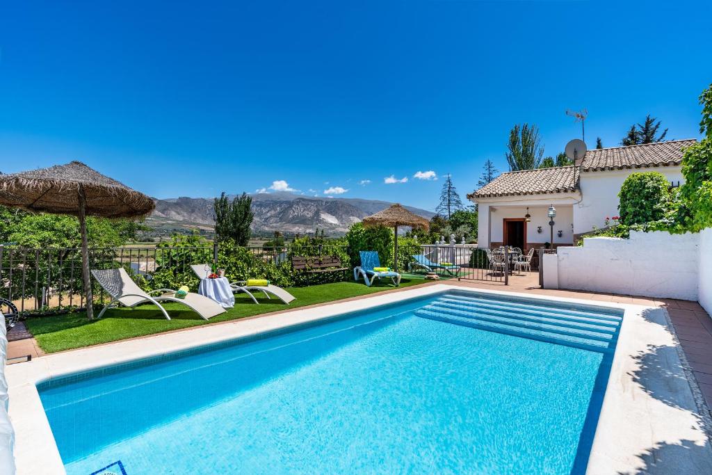 a swimming pool in the backyard of a house at Ladera de los molinos in Padul