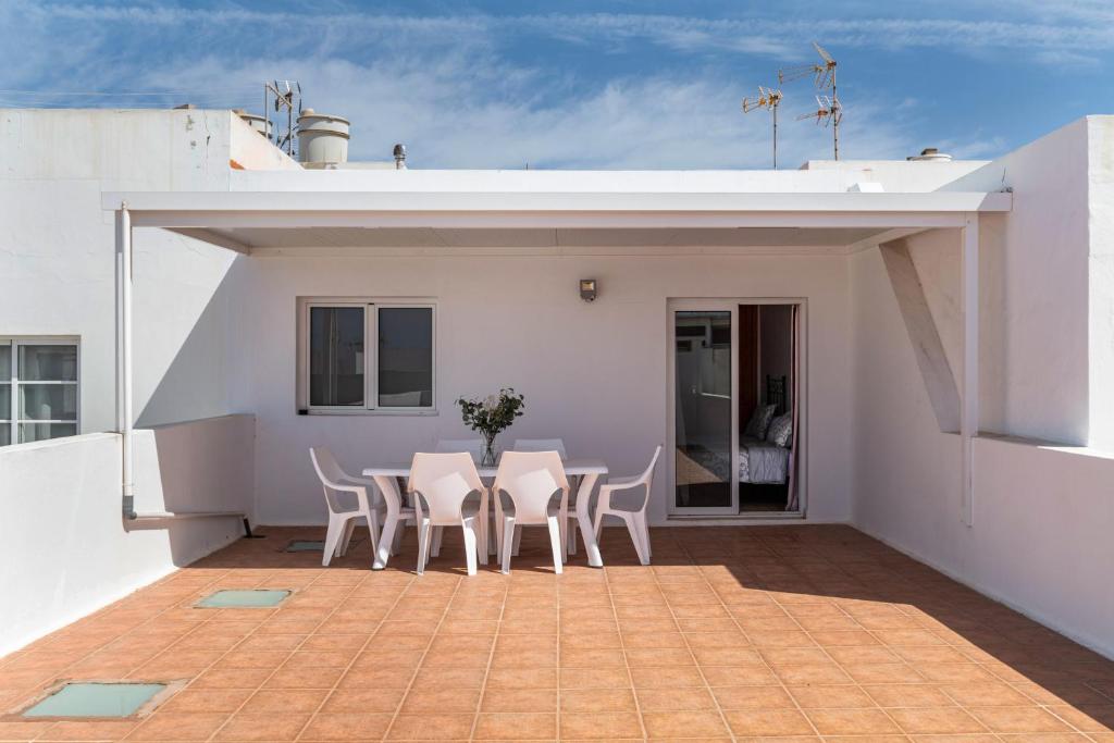 a patio with chairs and a table on a roof at Ganivet Home in Arrecife