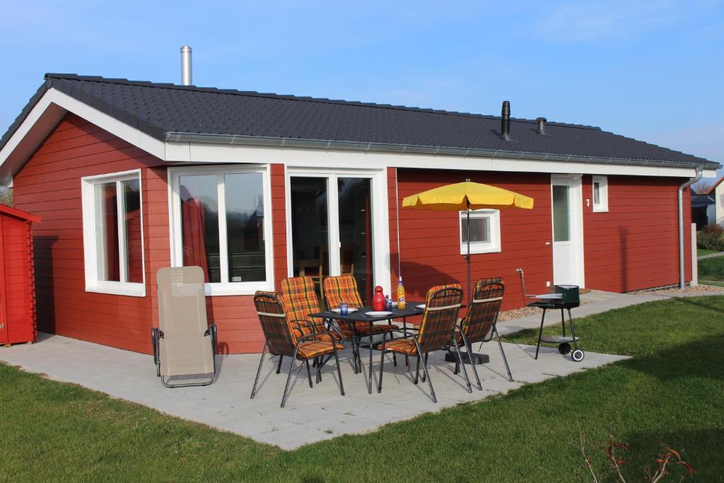 eine Terrasse mit einem Tisch und Stühlen vor einem Haus in der Unterkunft Ferienhaus Nixe7 in Dorum Neufeld