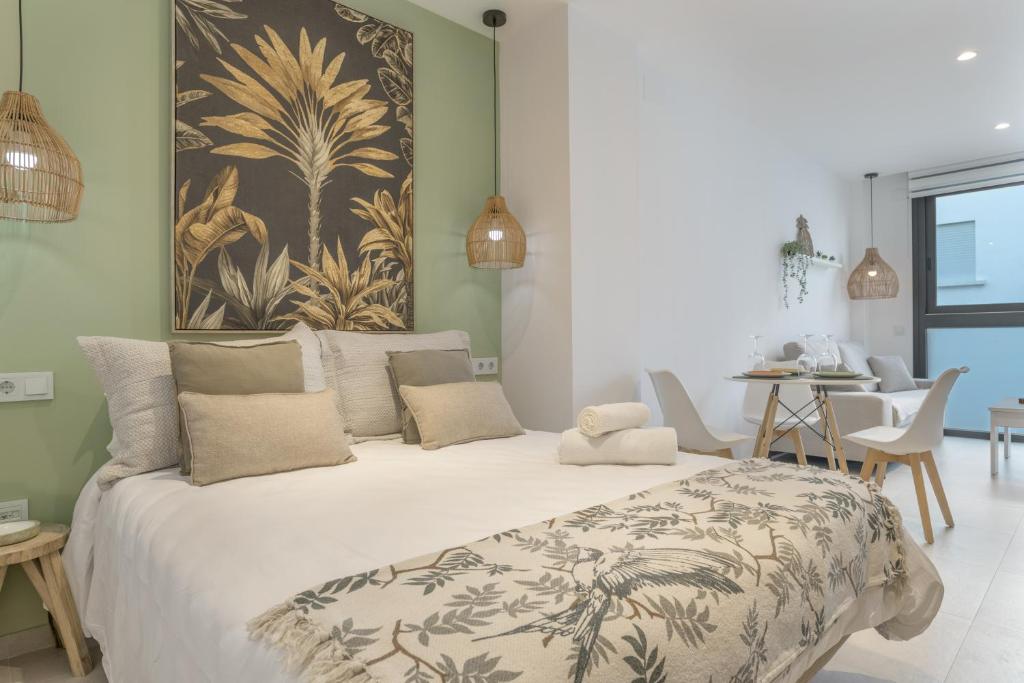 a bedroom with a large bed with a painting on the wall at Apartamento Black Palm 1 9 in Tarifa