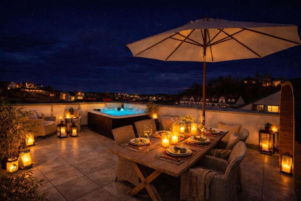 a patio with a table and an umbrella and a pool at The Summit Rooftop I Meissen in Meißen