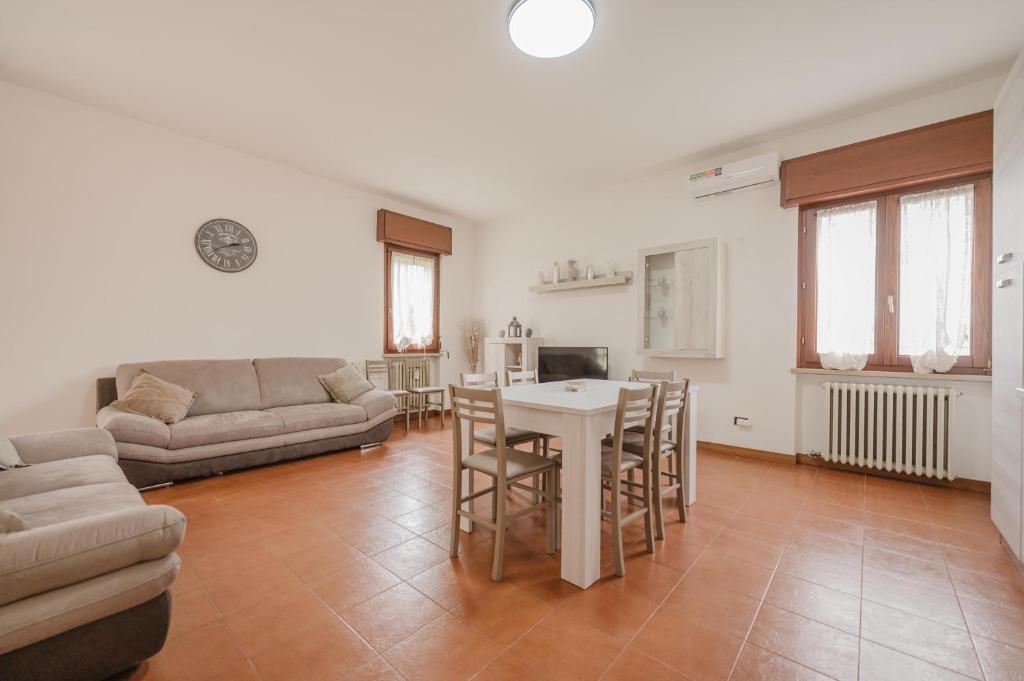 a living room with a table and a couch at La Fenice Private Gardent Free in Rivoli Veronese