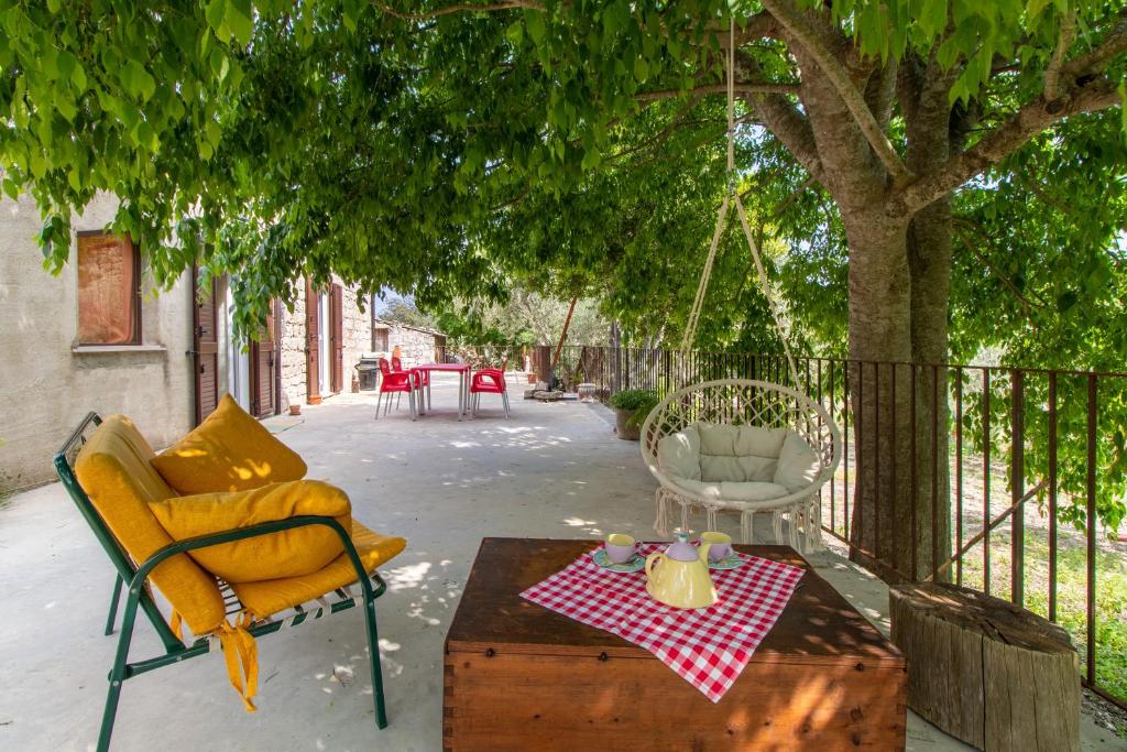 a patio with a swing and a table and chairs at Casa Il Carrubbo in Modica