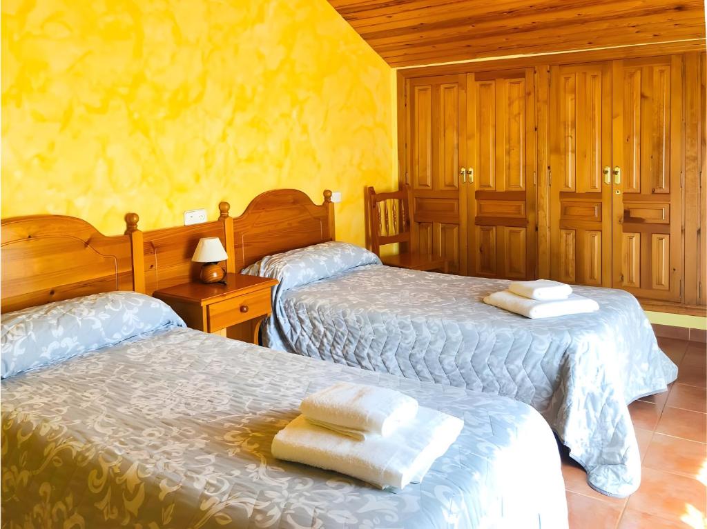 a bedroom with two beds with towels on them at Peña Yerga in Hospital