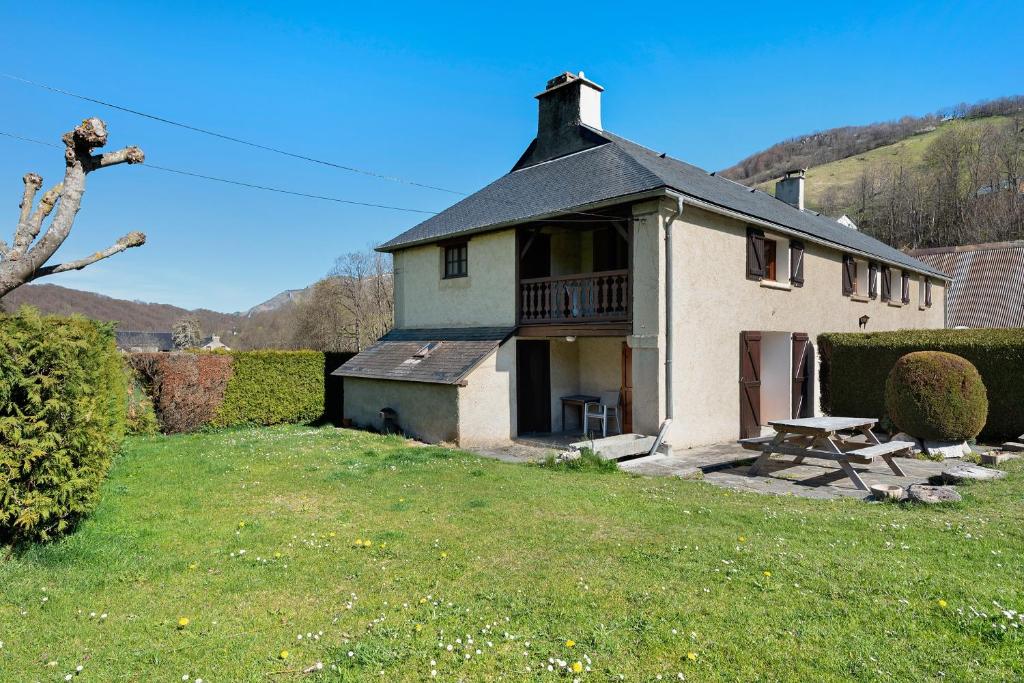 an old house with a picnic table in a yard at Gîte de La Séoube in Campan
