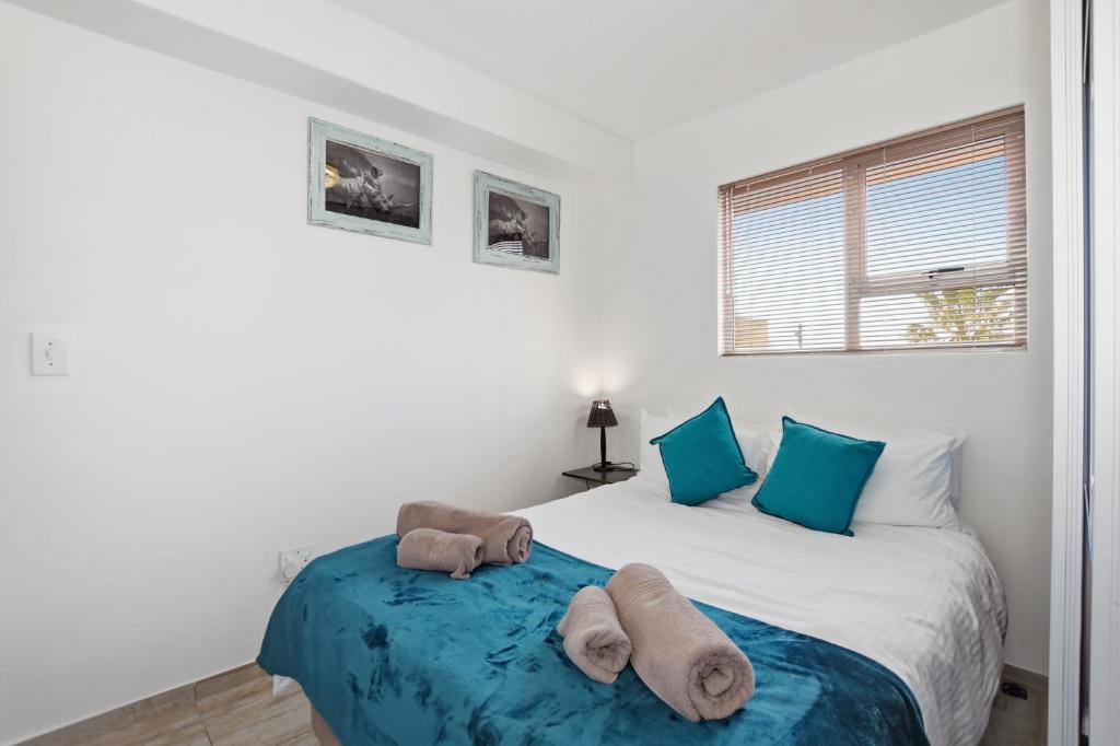 a bedroom with a bed with towels on it at Nautica by the Sea in Cape Town