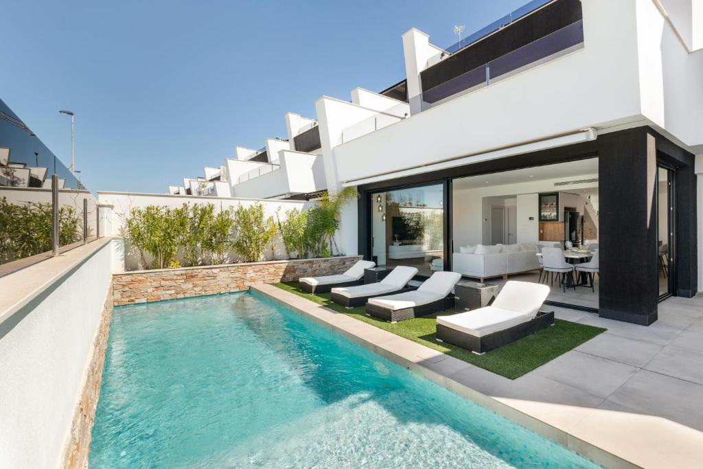 an image of a swimming pool in the backyard of a house at Chalet con Piscina en San Javier in San Javier