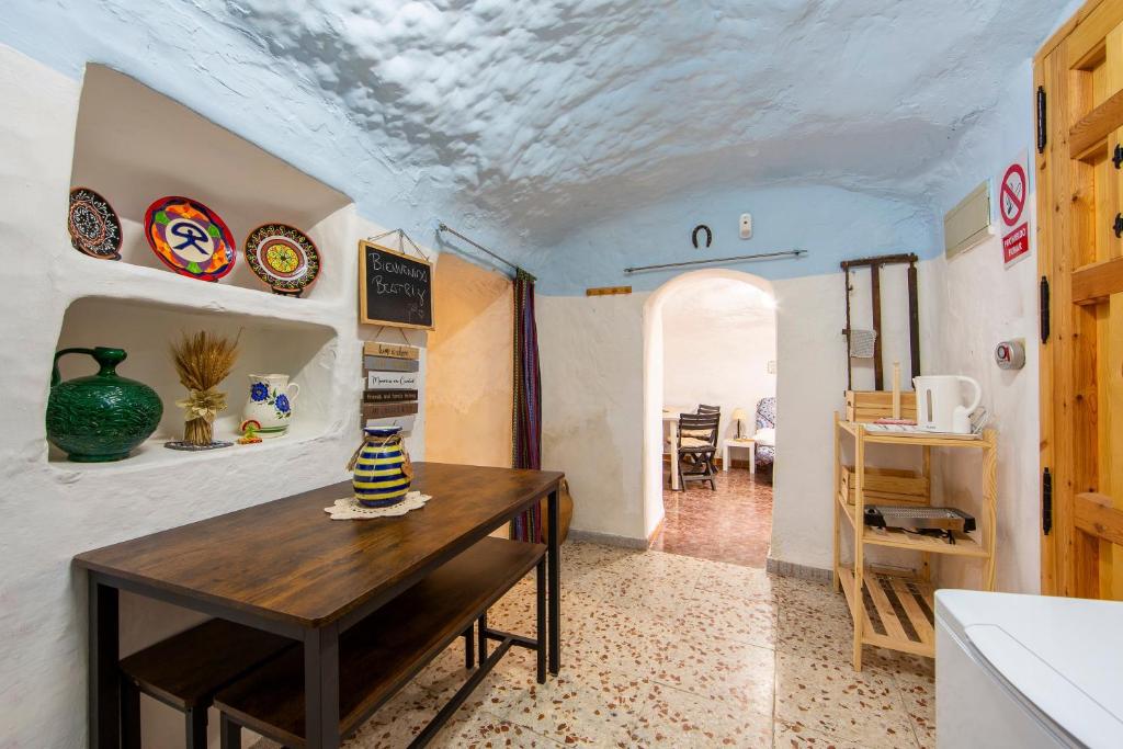 a dining room with a table and a room with a ceiling at Cueva in Almería