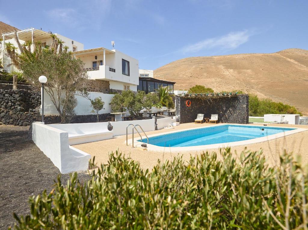 a swimming pool in front of a house at Finca La Calerita C in Yaiza