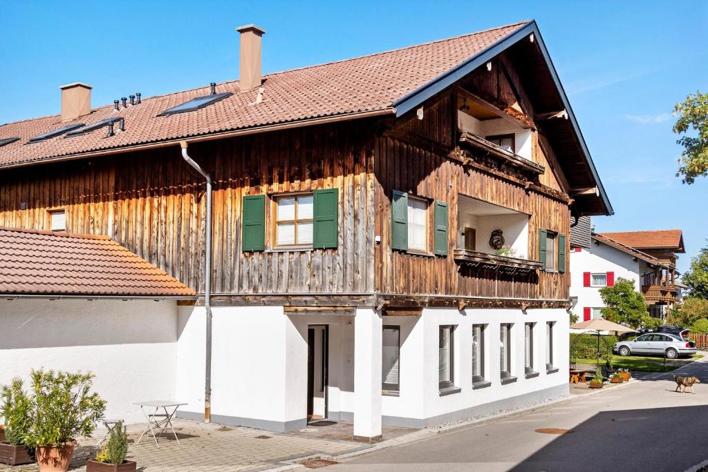an old wooden house with a white building at Ferienwohnung Götz in Roßhaupten