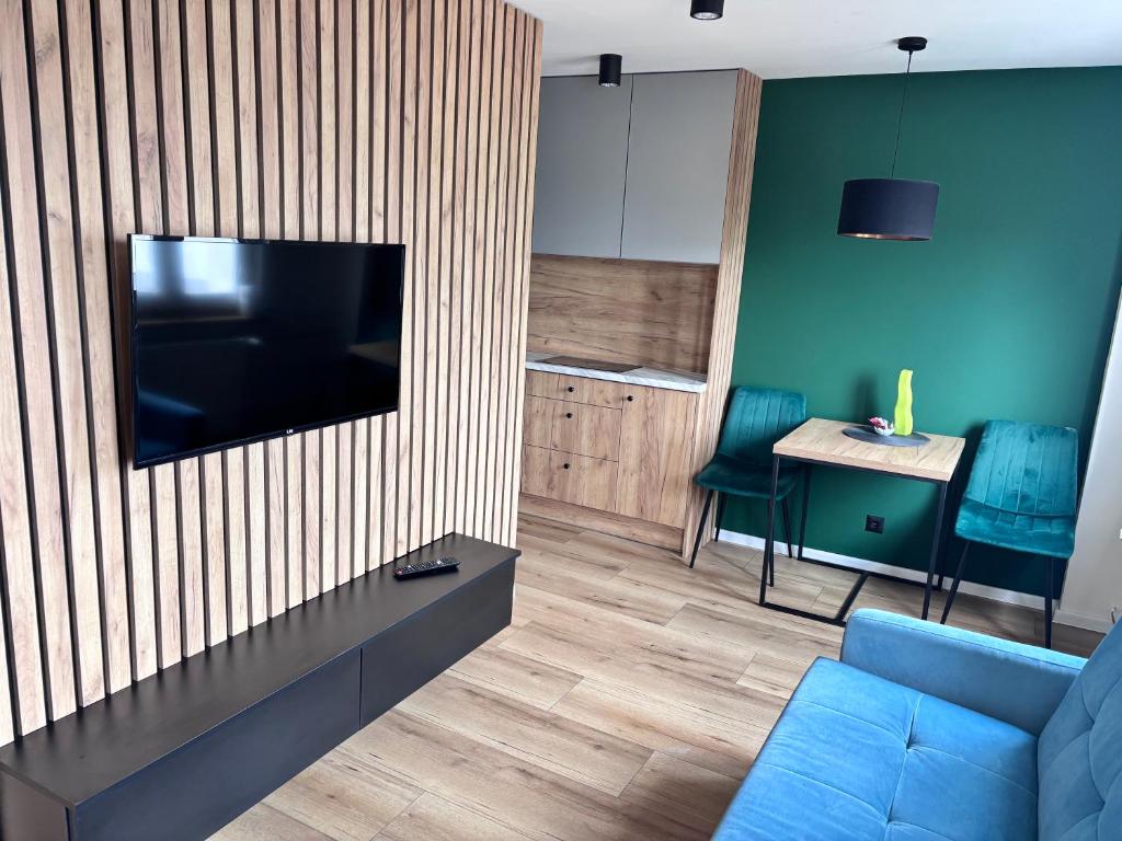 a living room with a couch and a television on a wall at elli apartament Sieradz in Sieradz