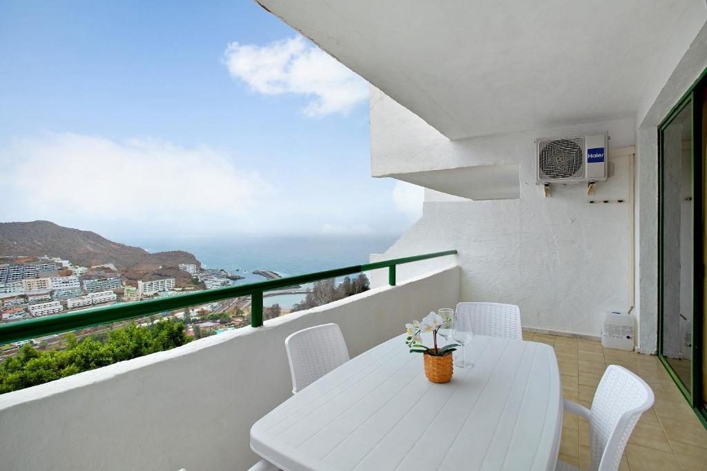 a white balcony with a white table and chairs at Casa Puerto Rico in Mogán