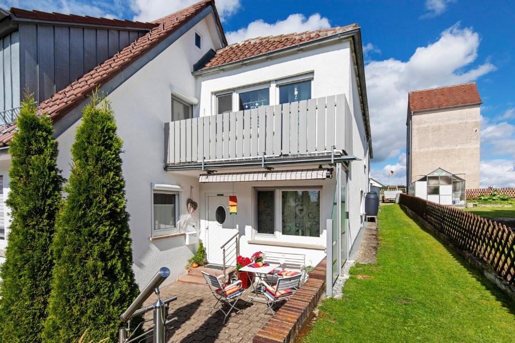 a white house with a table and chairs at Ferienwohnung Steffi in Laichingen