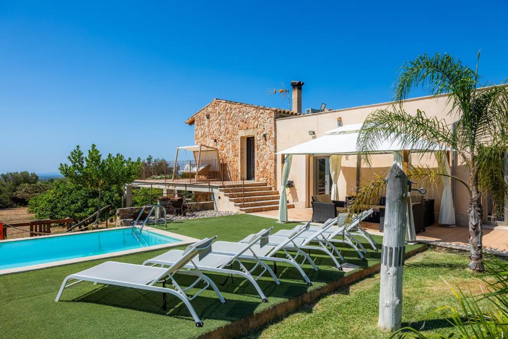 a villa with a swimming pool and lounge chairs at Finca Son Montserrat in Llucmajor